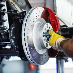 Mechanic servicing European car brake disc and calliper at Brisbane workshop