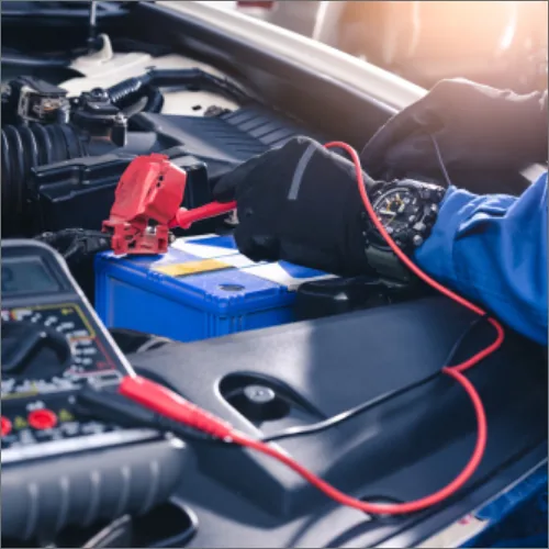 Mechanic jump-starting European car battery with jumper leads under bonnet Brisbane