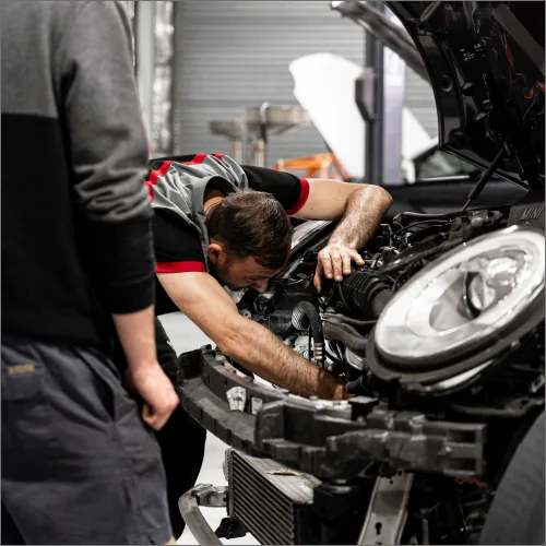 Experienced mechanic performing European car engine repairs under bonnet at Brisbane workshop