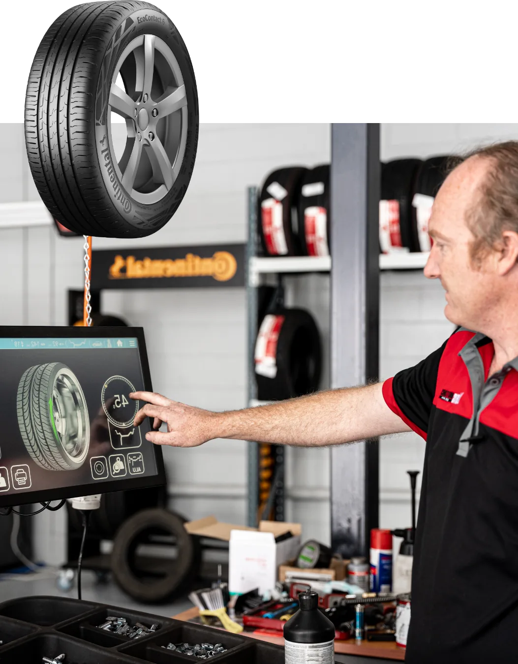 Mechanic using digital tyre analysis system at European car service workshop