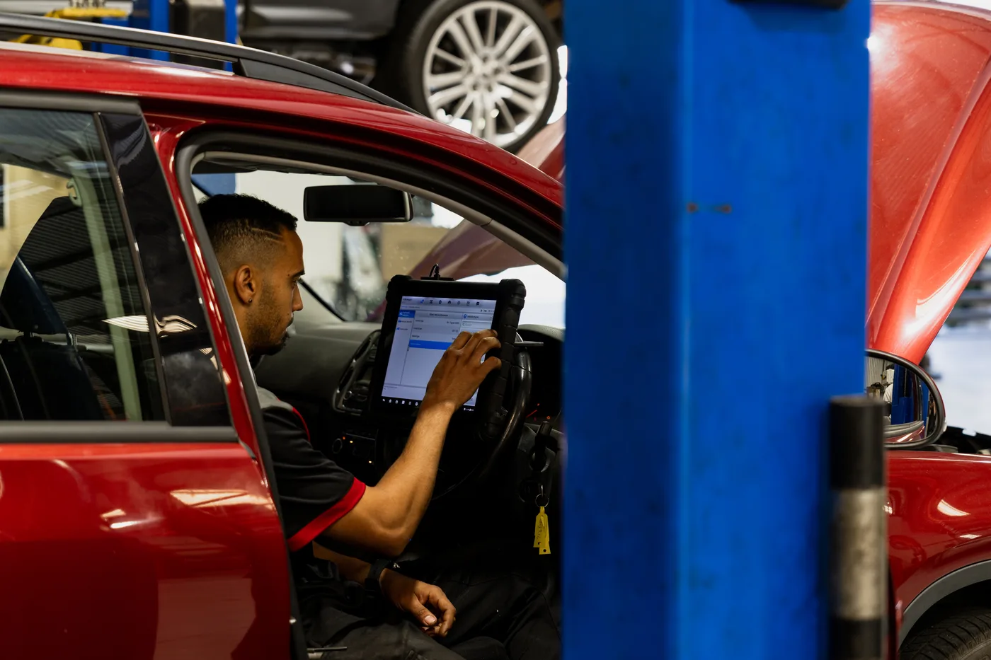 Bosch Service Brisbane technician registering a new battery with a diagnostic scan tool